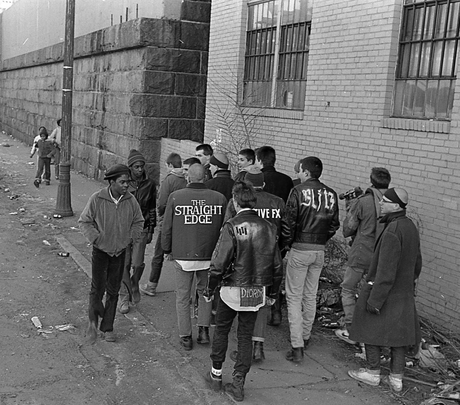 The Boston Crew gathered on a city sidewalk in painted jackets reading The Straight Edge, Negative FX, and Blitz.