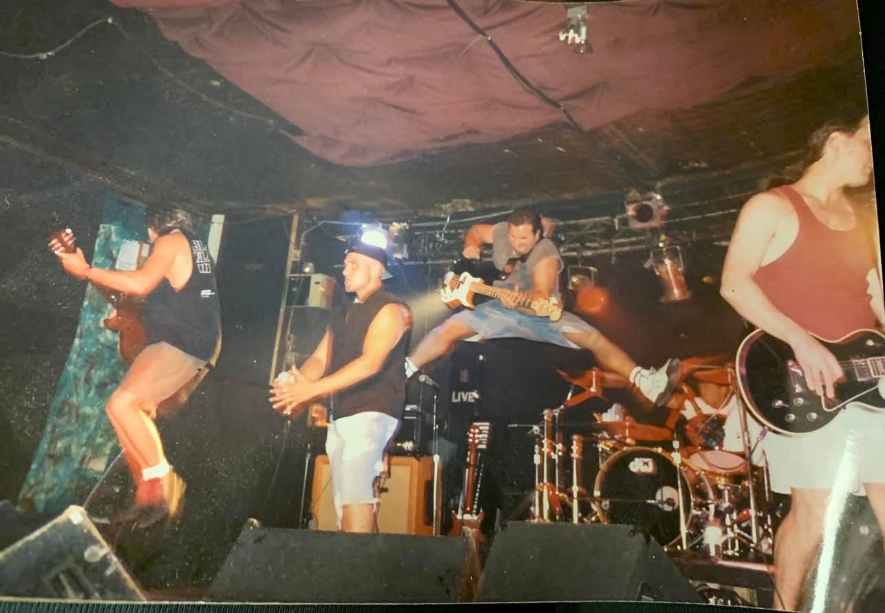 GAGE playing a club show, the bassist leaping off the drum riser mid-song between the singer and the guitarists.