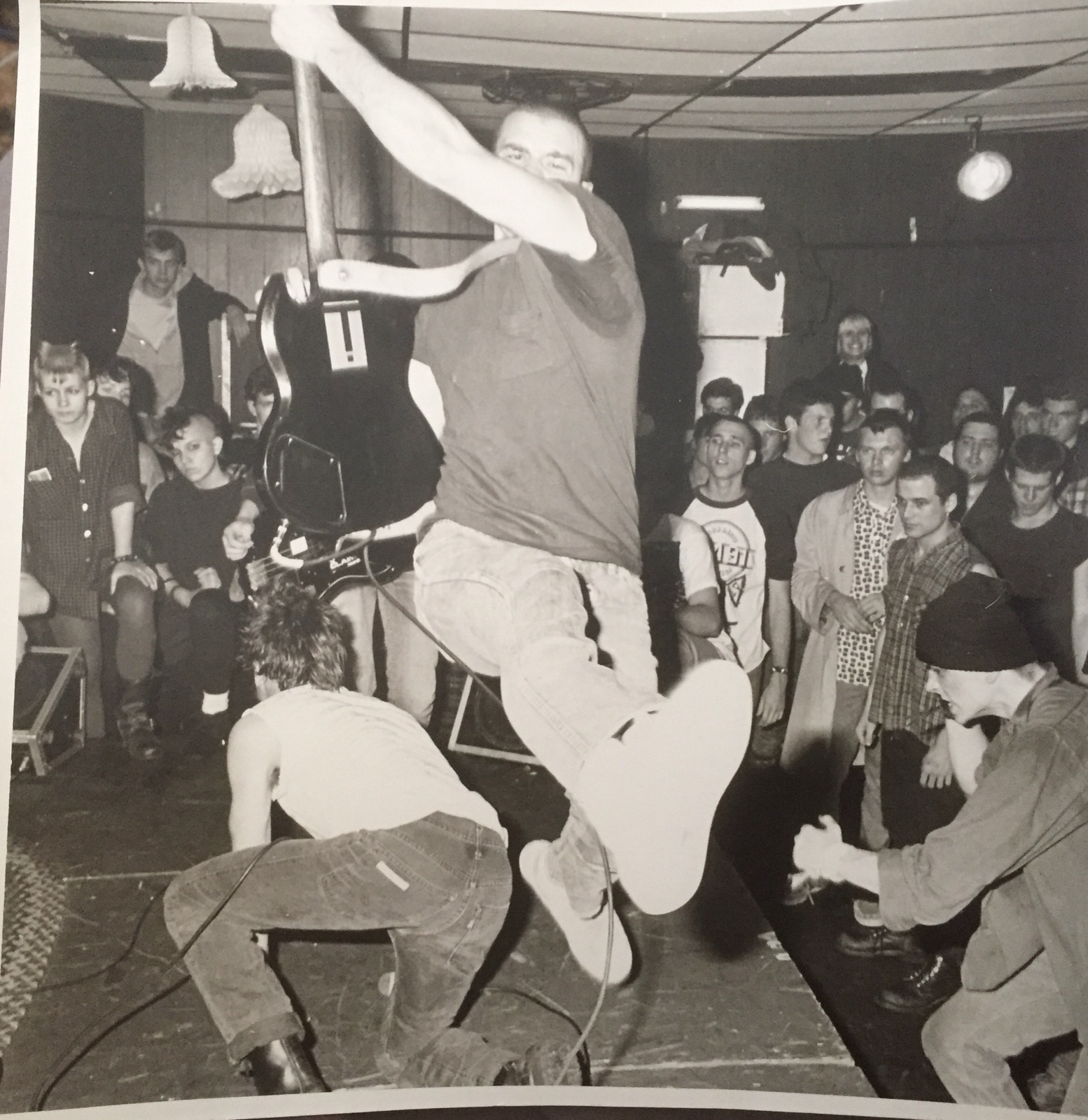 A fan leaps high into the air off the stage at an SSD show while the crowd rings the dance floor.